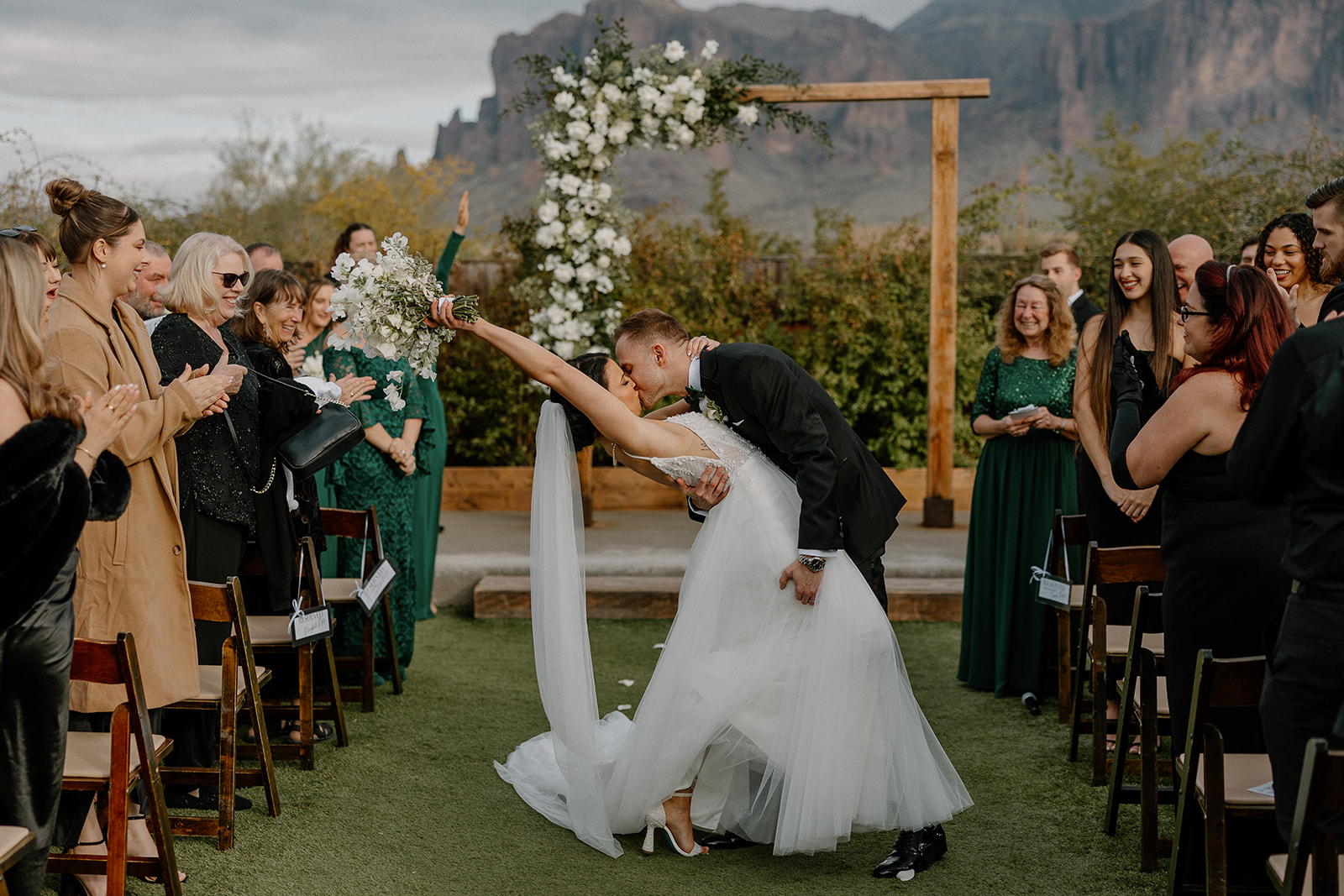 bride and groom share a kiss together as they exit their wedding day