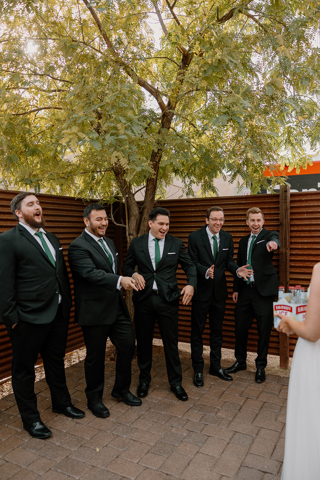 bride and groomsmen share a first look photo together, make sure to include ample time for first look photos in your wedding day timeline!