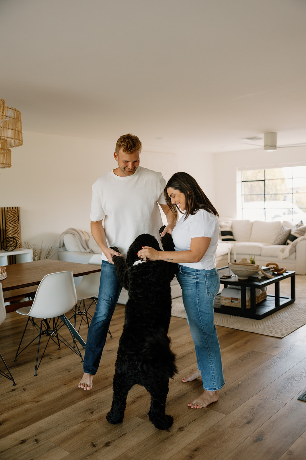 beautiful couple pose with their dogs during their in home engagement session