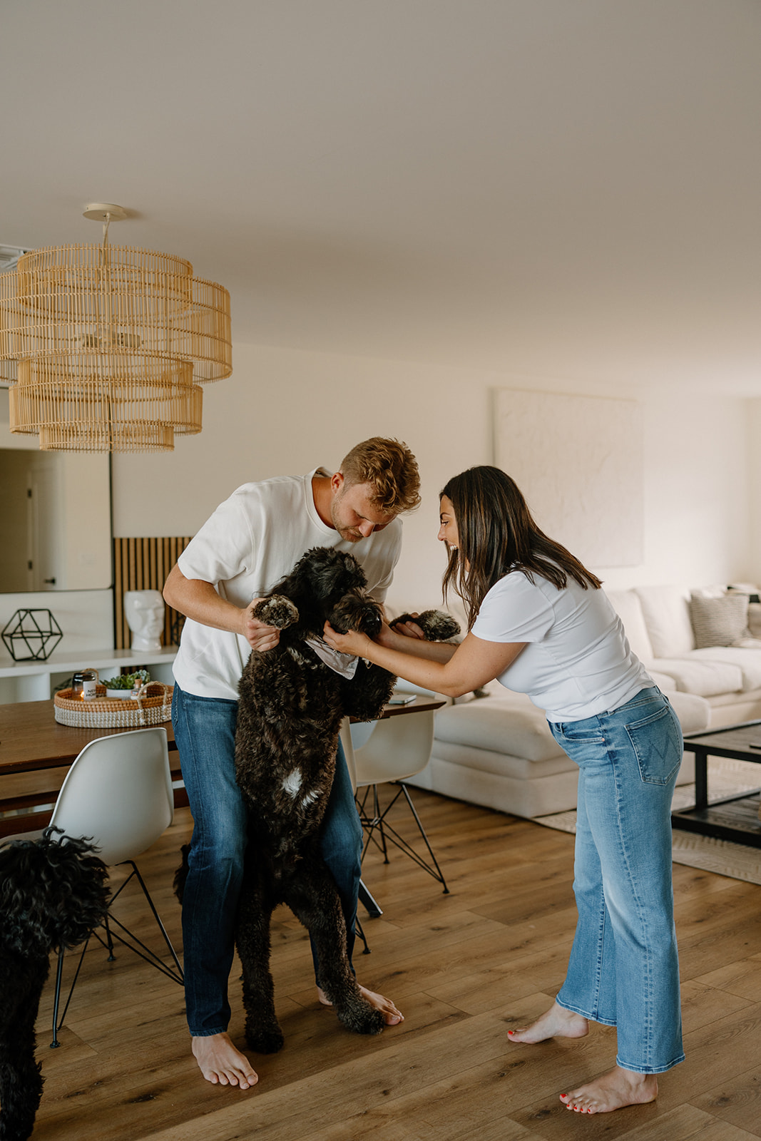 beautiful couple pose with their dogs during their in home engagement session