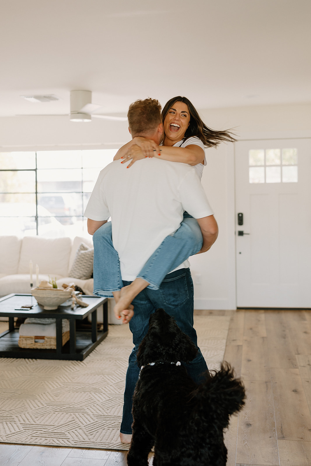 beautiful couple pose with their dogs during their in home engagement session