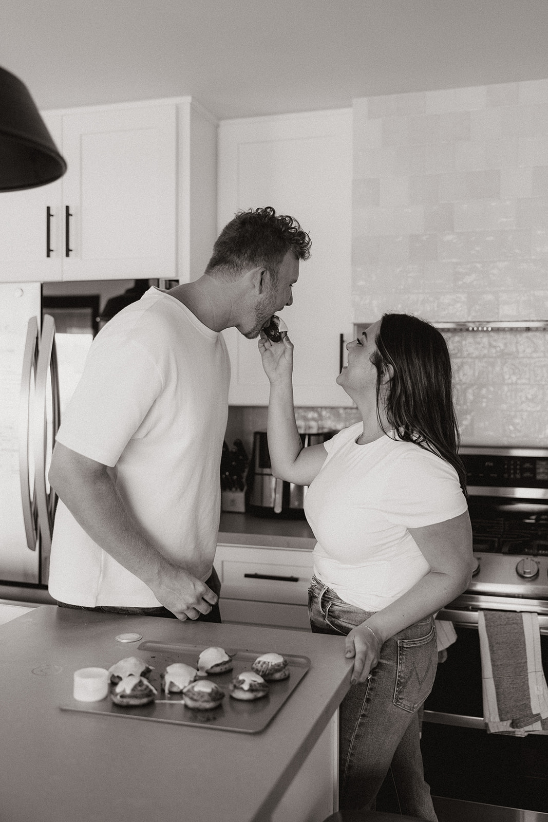 couple cooks together during their in home engagement photoshoot