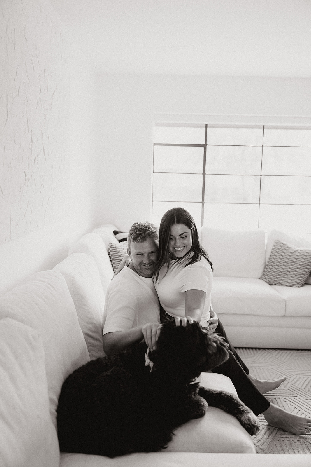 beautiful couple pose with their dogs during their in home engagement session