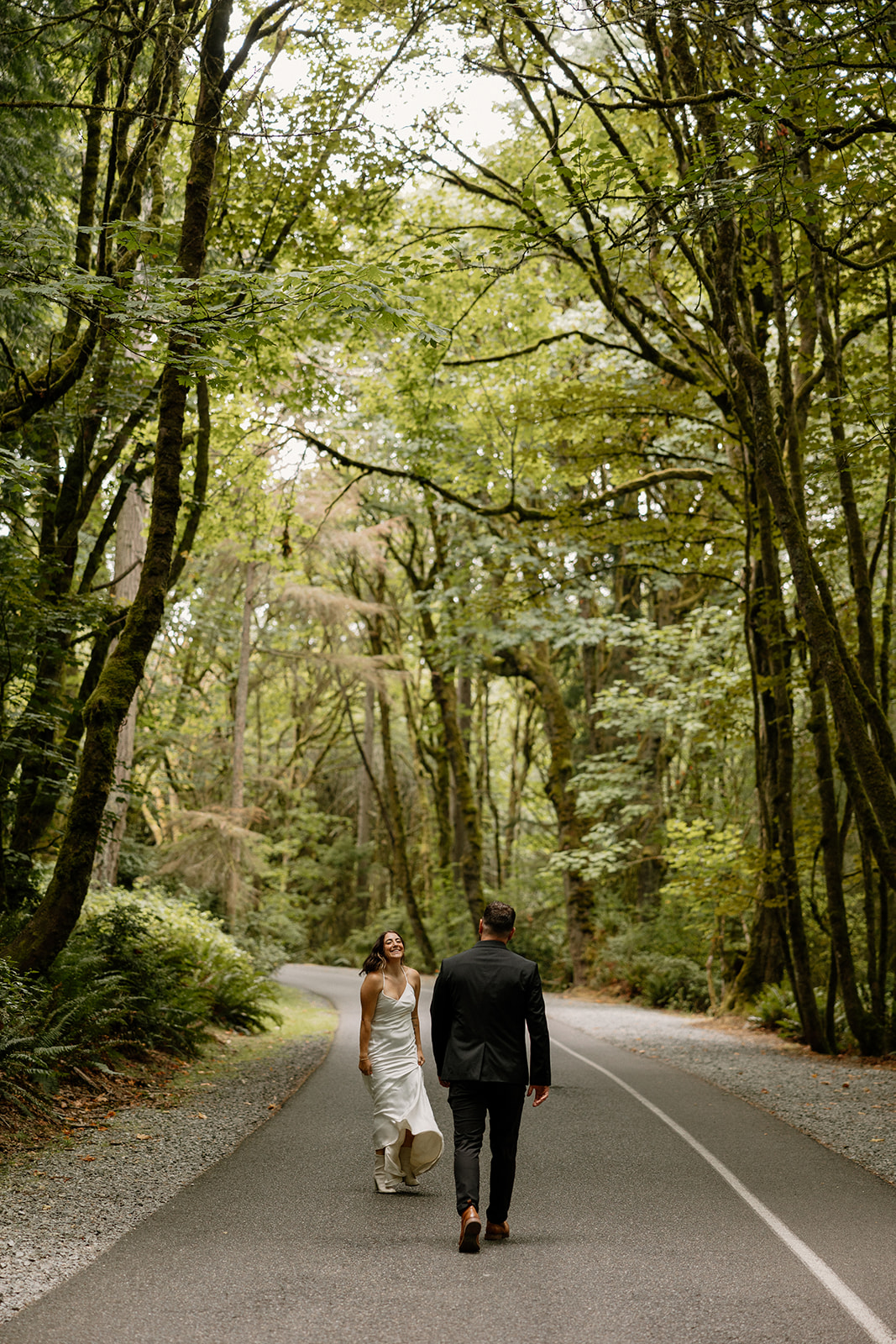 beautiful couple walk through on the forest road together 