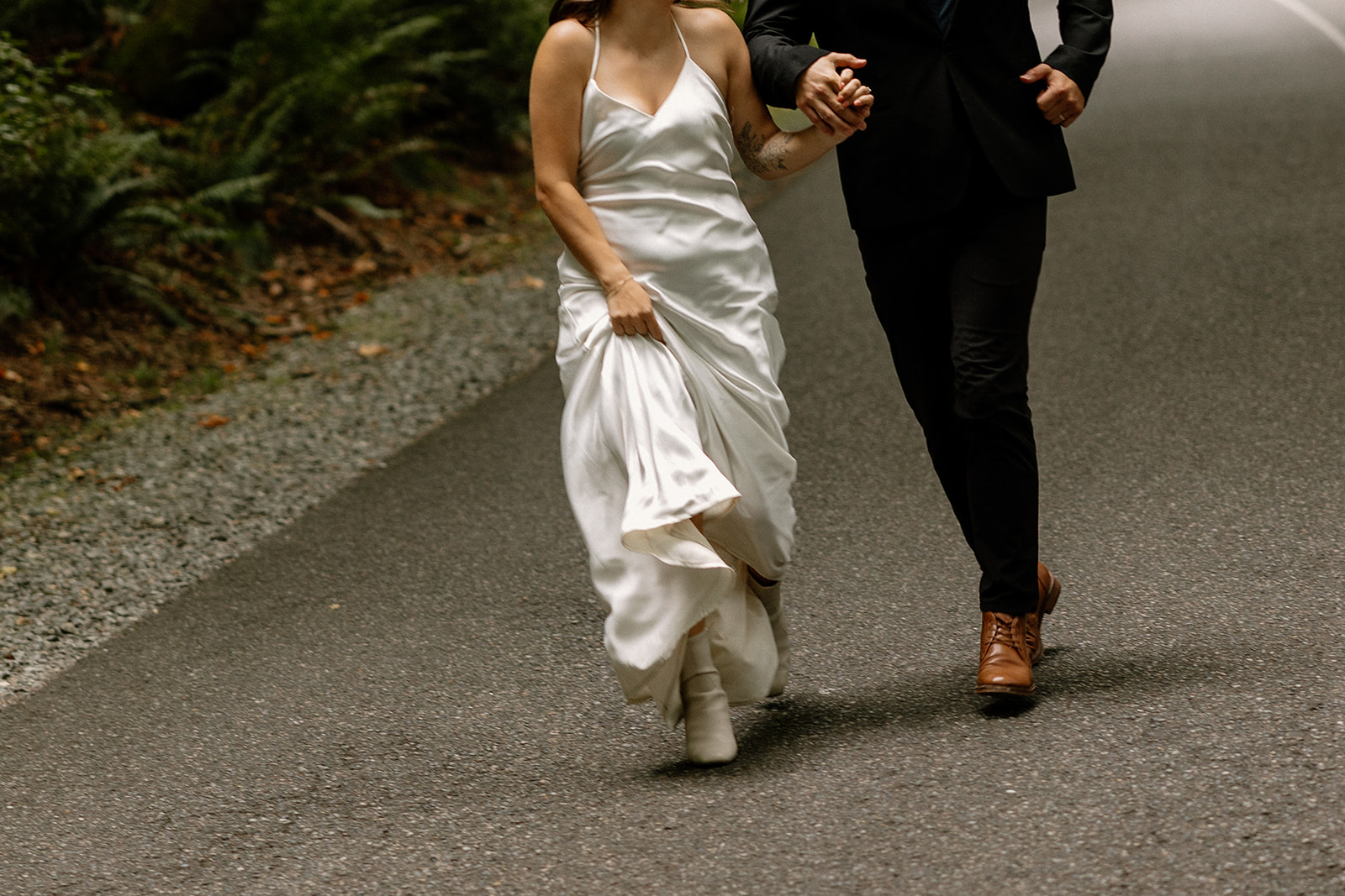 beautiful couple walk through the forest together during their PNW forest wedding anniversary photoshoot