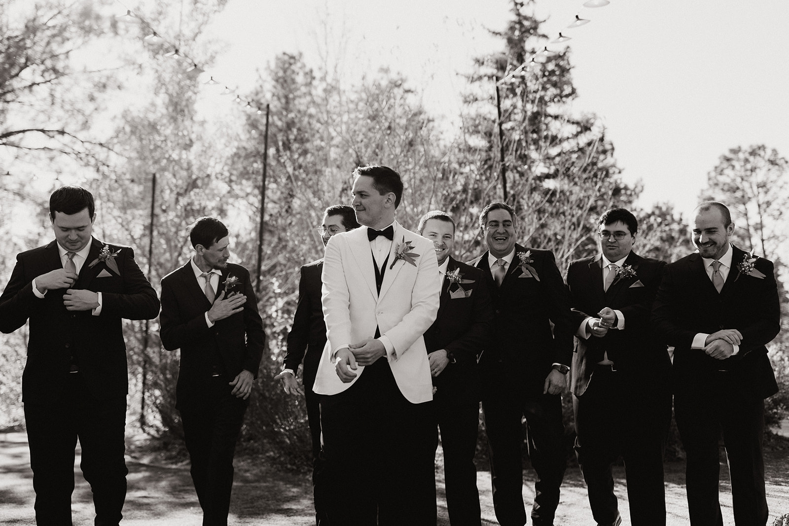 groom poses with her groomsmen in the Arizona forest