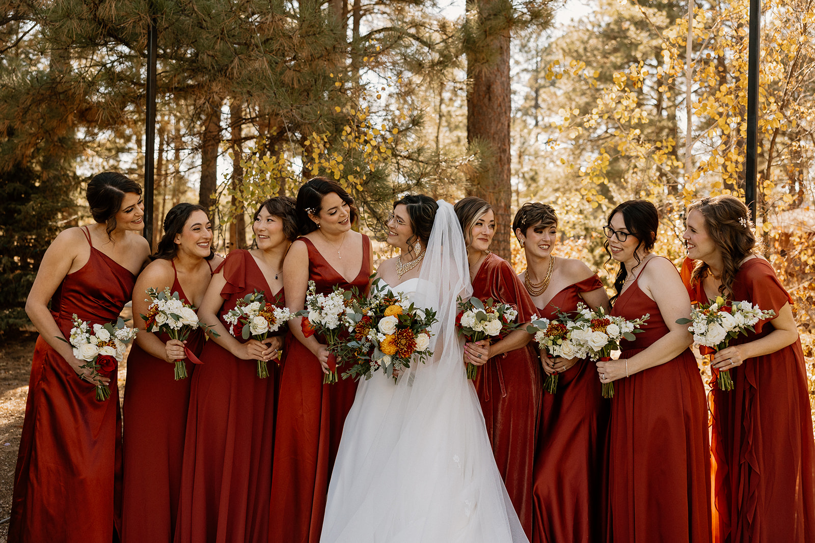 bride poses with her bridesmaids in the Arizona forest