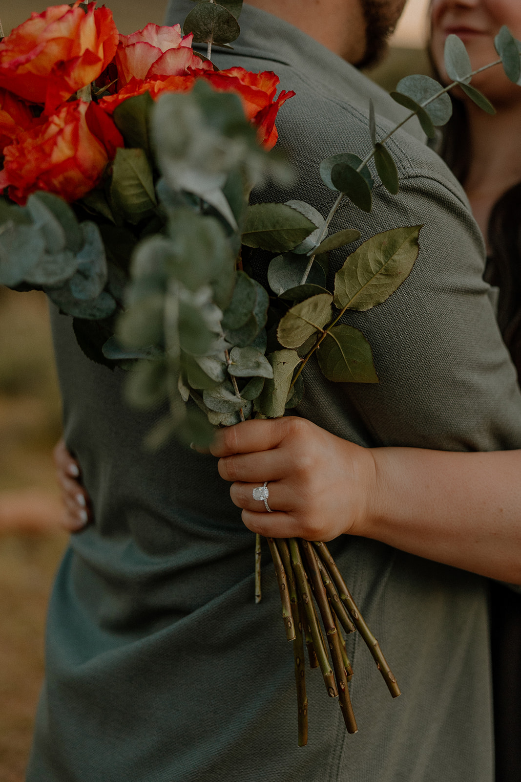 couple pose with red florals in the Arizona wilderness