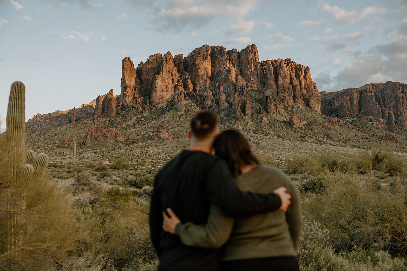 couple pose together in front of an Arizona mountain range