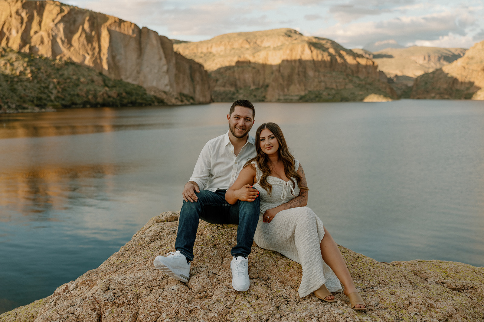 beautiful couple pose together beside the water during their water engagement photos