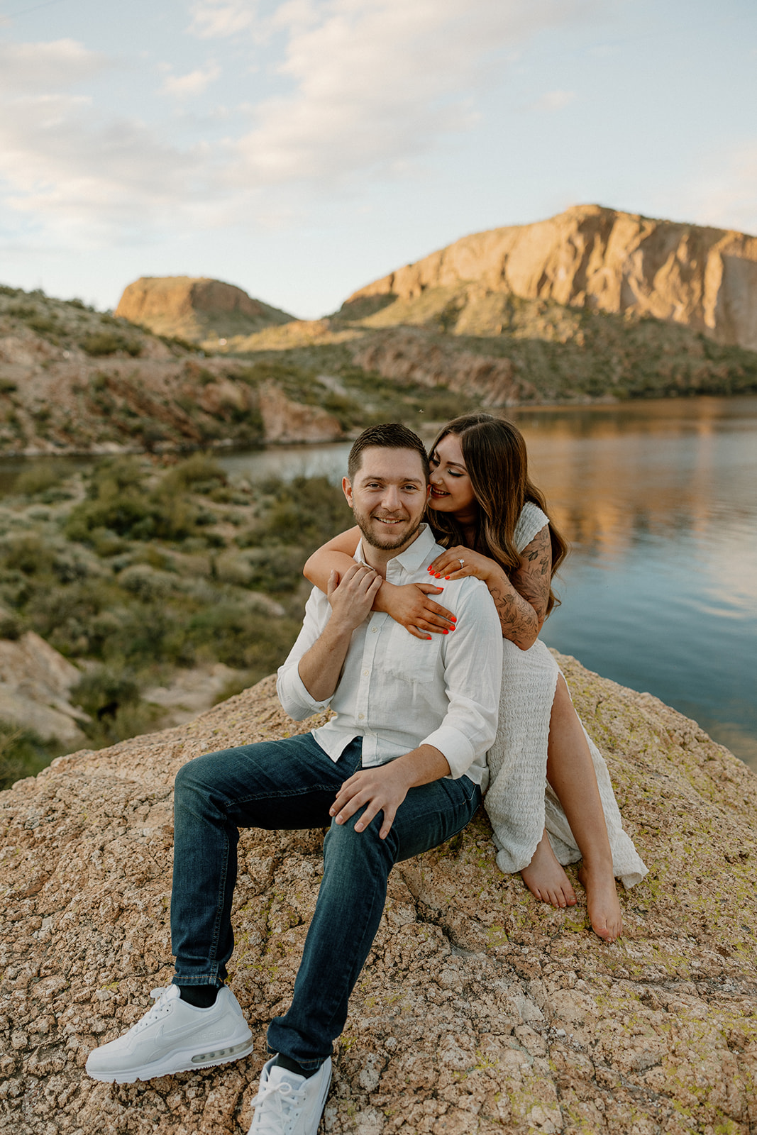 beautiful couple pose together beside the water during their water engagement photos