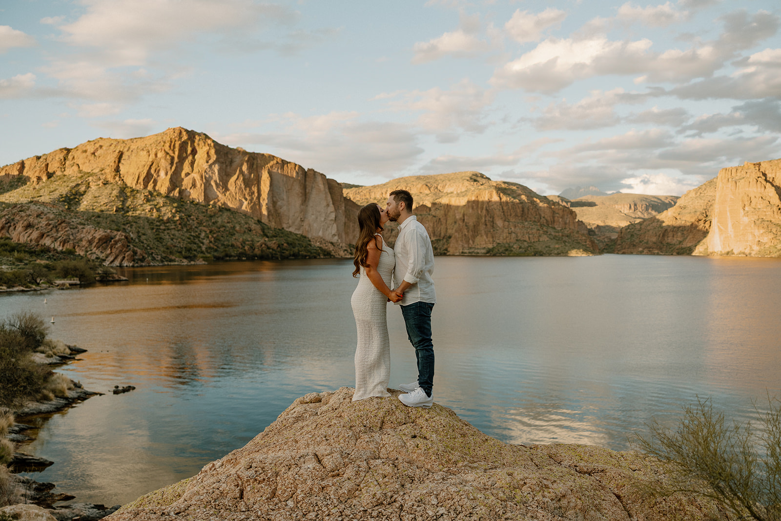 beautiful couple pose together beside the water during their water engagement photos