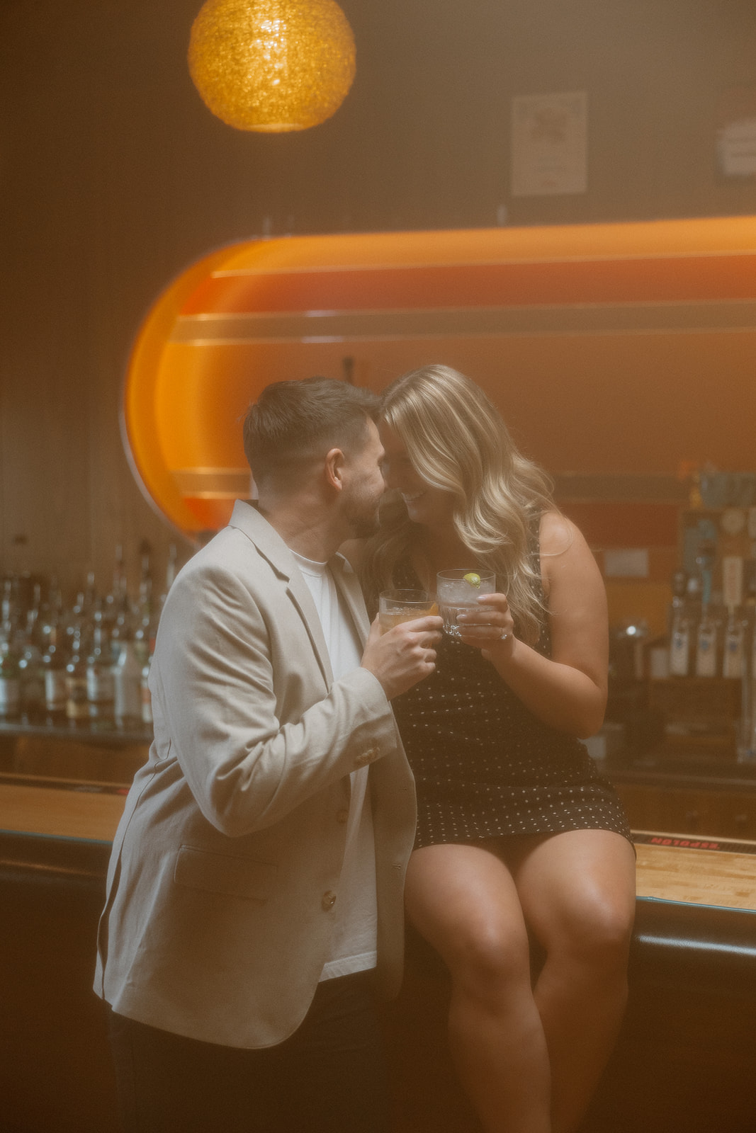 gorgeous couple takes their engagement photoshoot indoors to their favorite bar