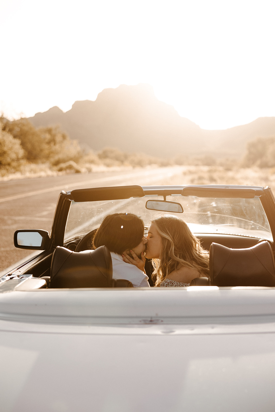 beautiful couple share an intimate moment together with a vintage car in the Arizona desert