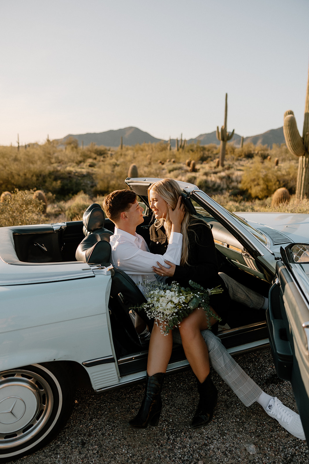 beautiful couple pose with a vintage car in the Arizona desert