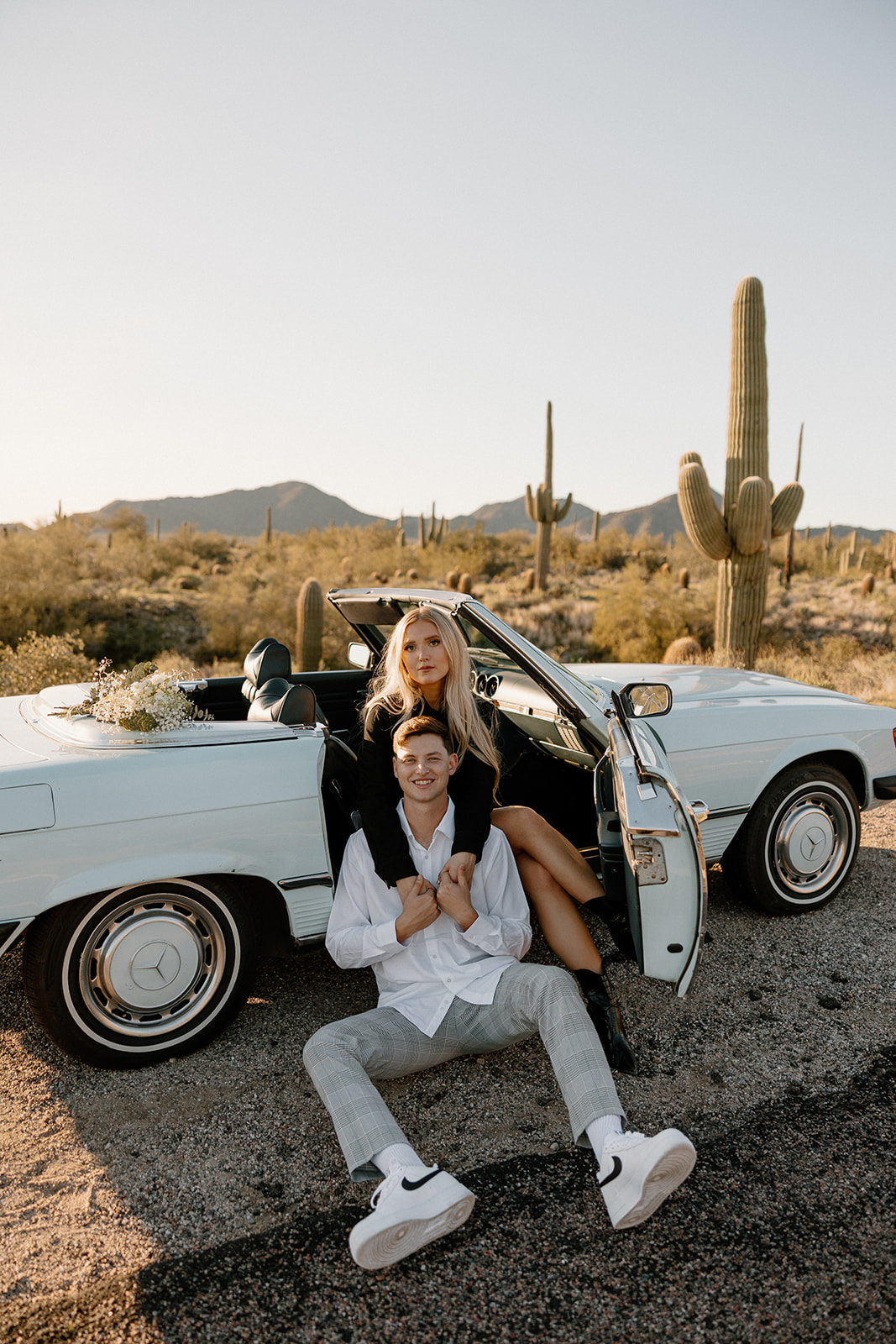 beautiful couple pose with a vintage car in the Arizona desert