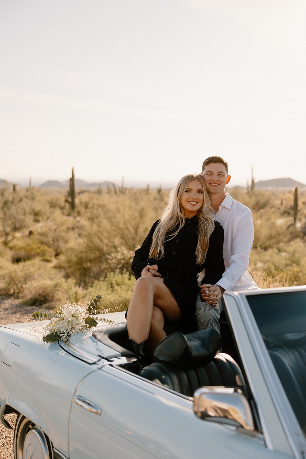 beautiful couple pose with a vintage car in the Arizona desert