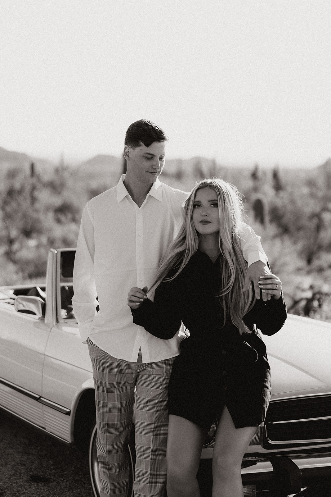 beautiful couple pose with a vintage car in the Arizona desert