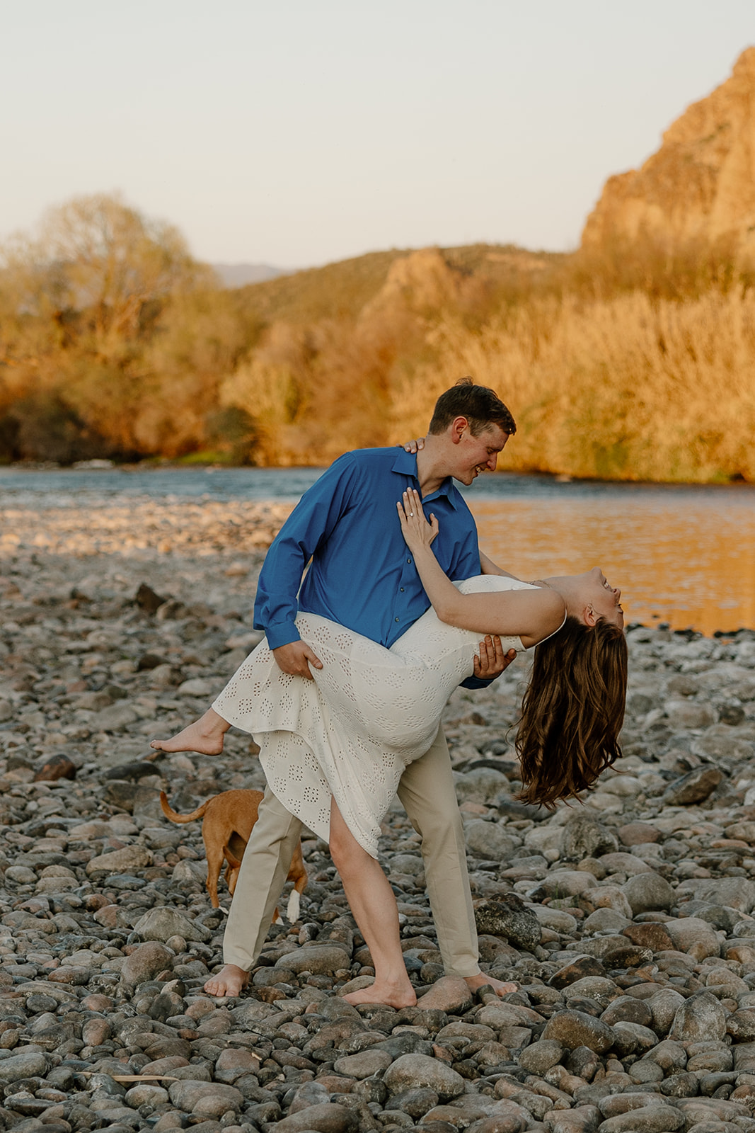 beautiful couple pose together beside the water during their water engagement photos