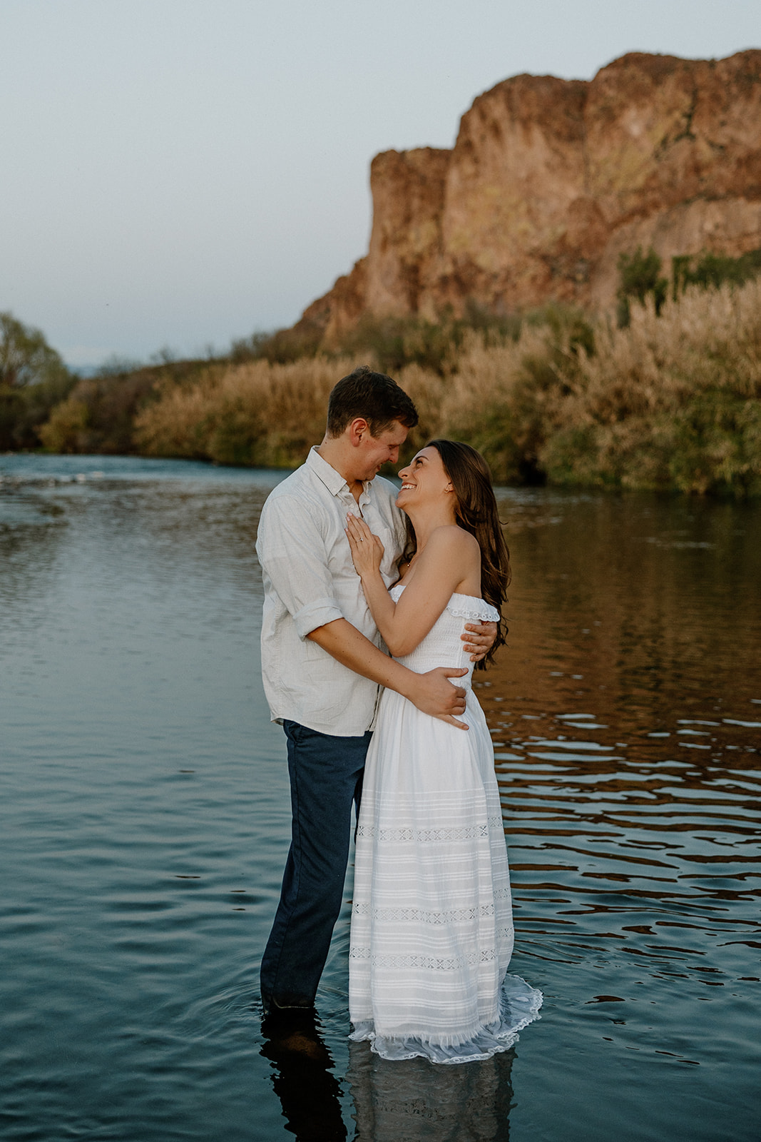 couple share intimate moments by the water during their Arizona engagement photoshoot