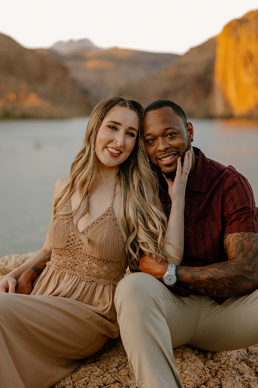 beautiful couple pose together beside the water during their water engagement photos