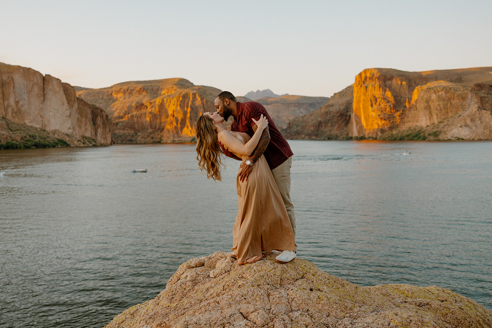 beautiful couple pose together beside the water during their water engagement photos