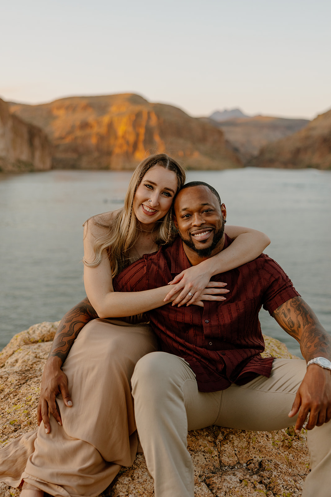 beautiful couple pose together beside the water during their water engagement photos