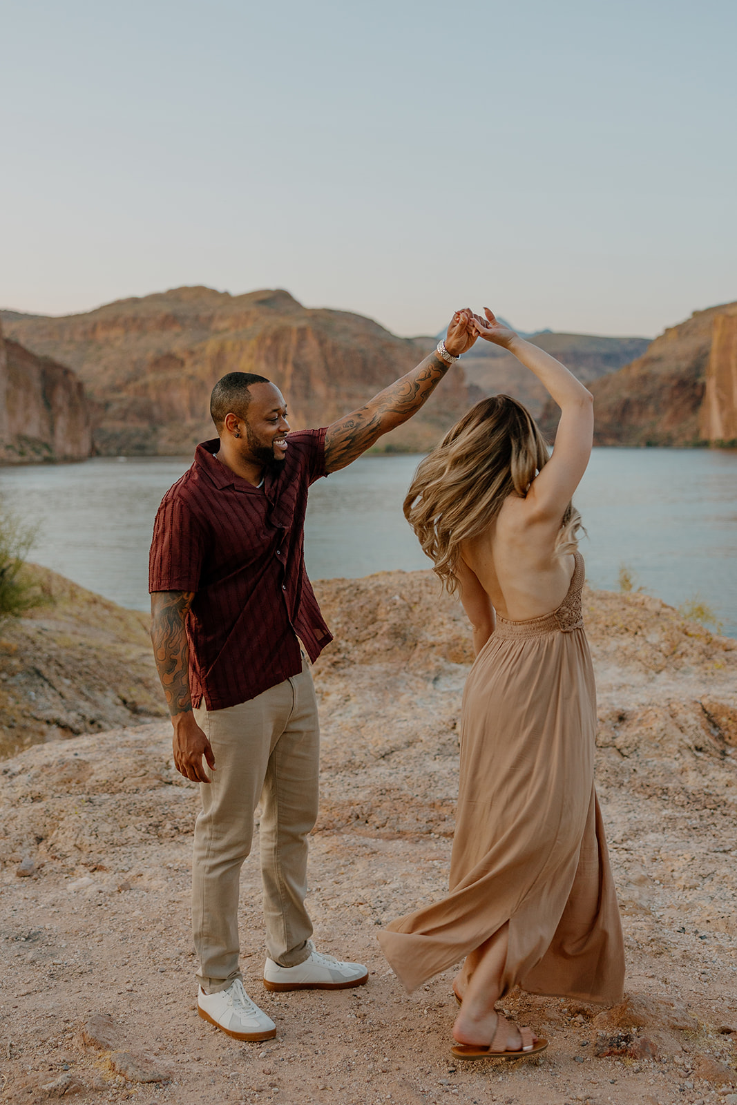 beautiful couple pose together beside the water during their water engagement photos