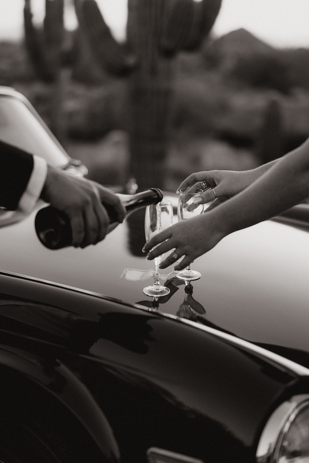 stunning couple pose with a vintage car during their engagement photos in the Arizona dessert