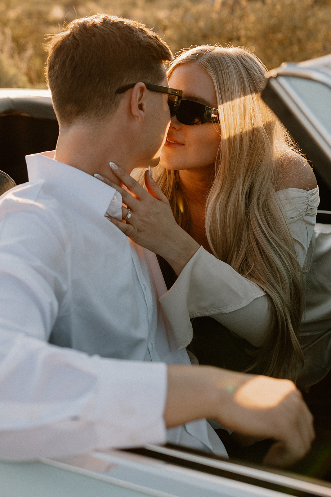 stunning couple pose with a vintage car during their engagement photos in the Arizona dessert