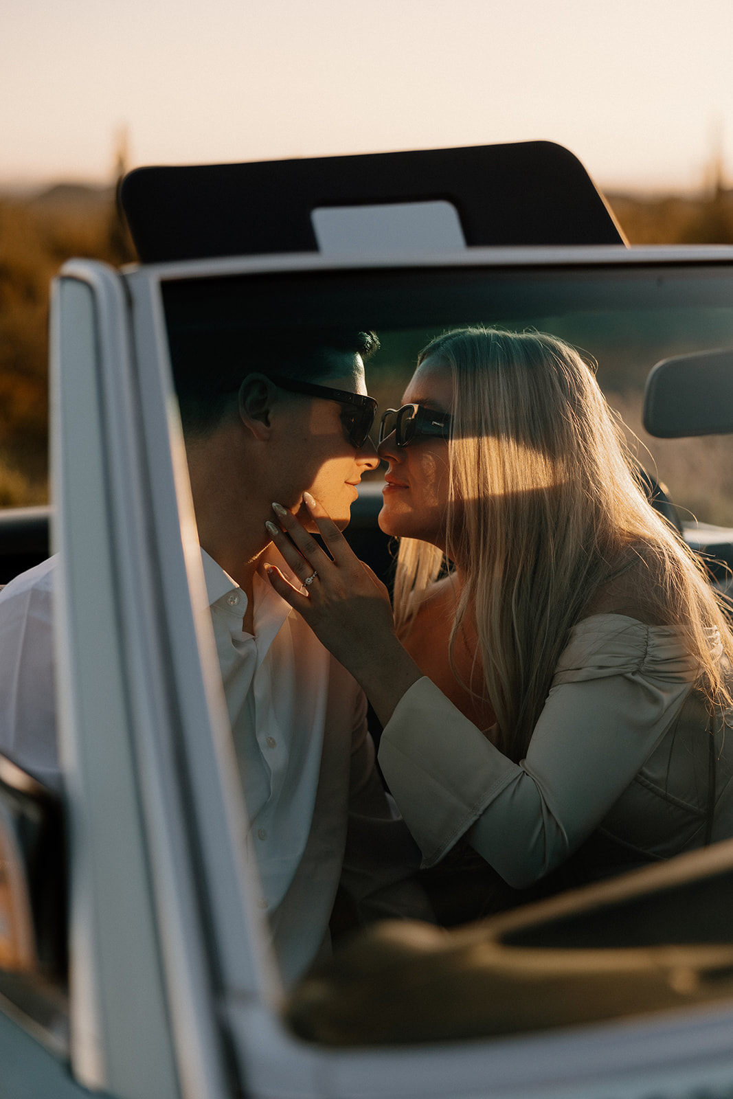 stunning couple pose with a vintage car during their engagement photos in the Arizona dessert