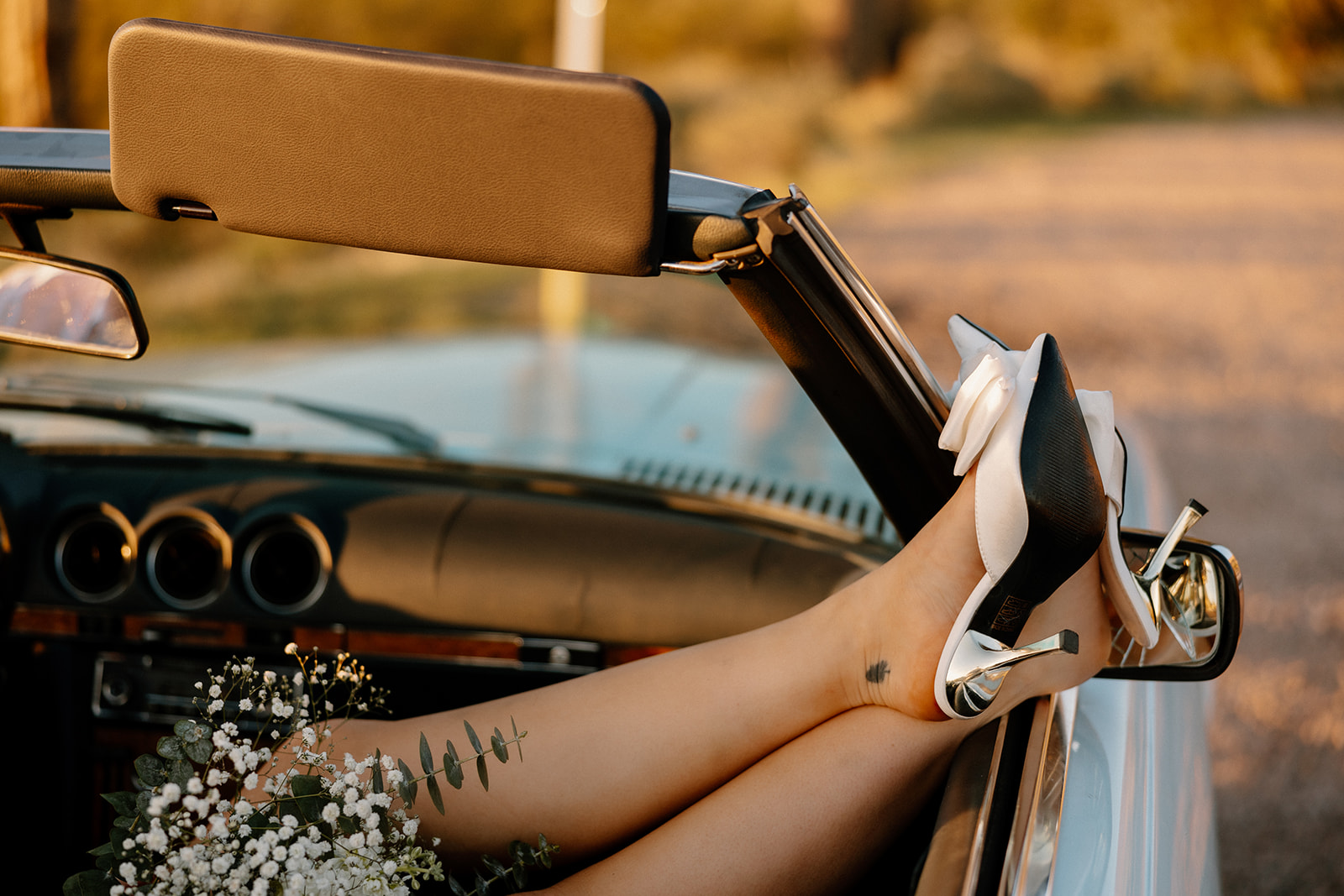 stunning couple pose with a vintage car during their engagement photos in the Arizona dessert