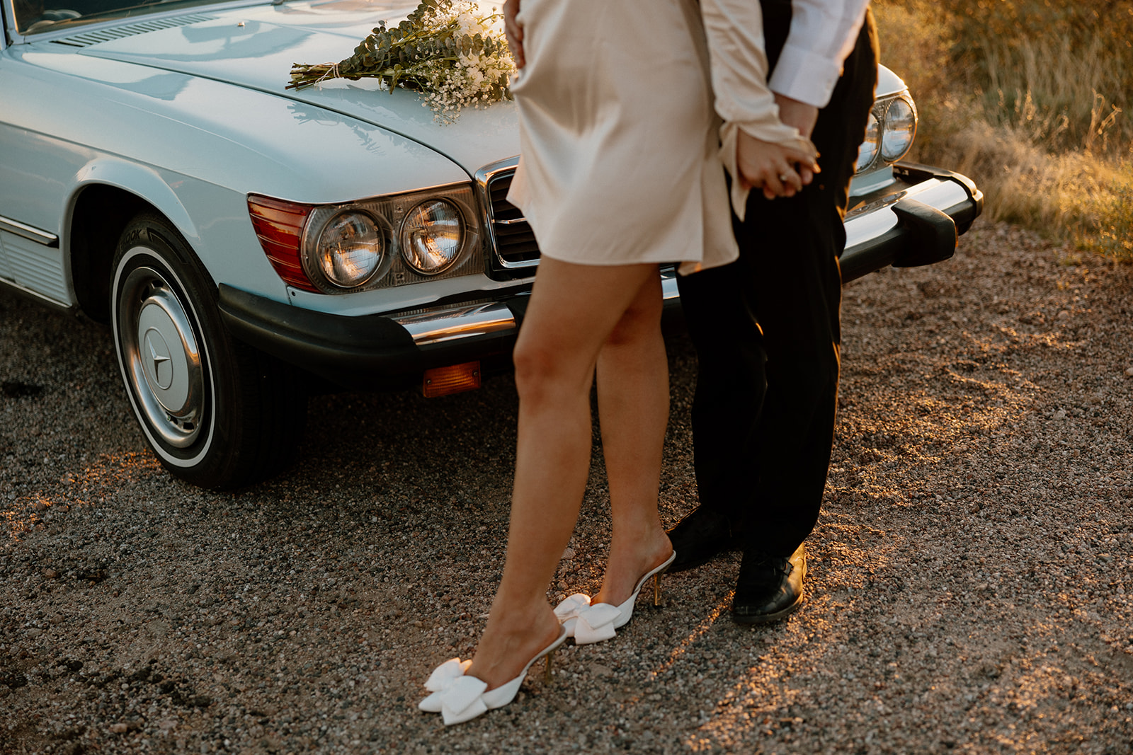 stunning couple pose with a vintage car during their engagement photos in the Arizona dessert