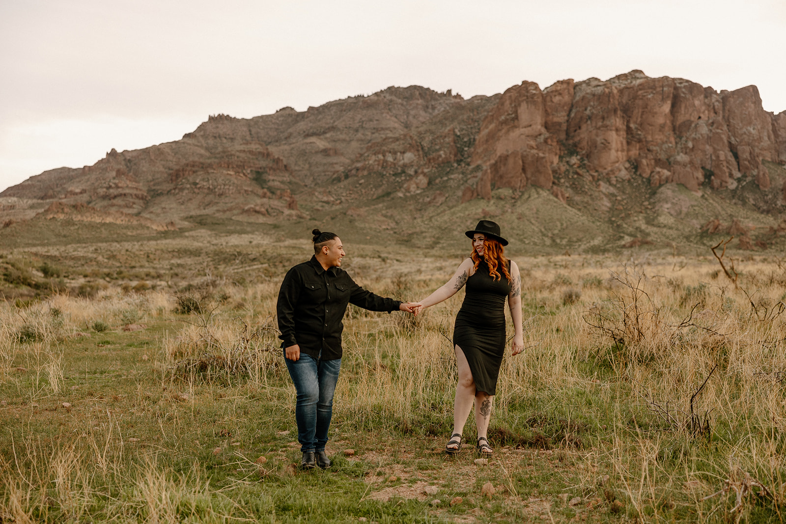 same sex couple pose together during their engagement photos at superstition mountain