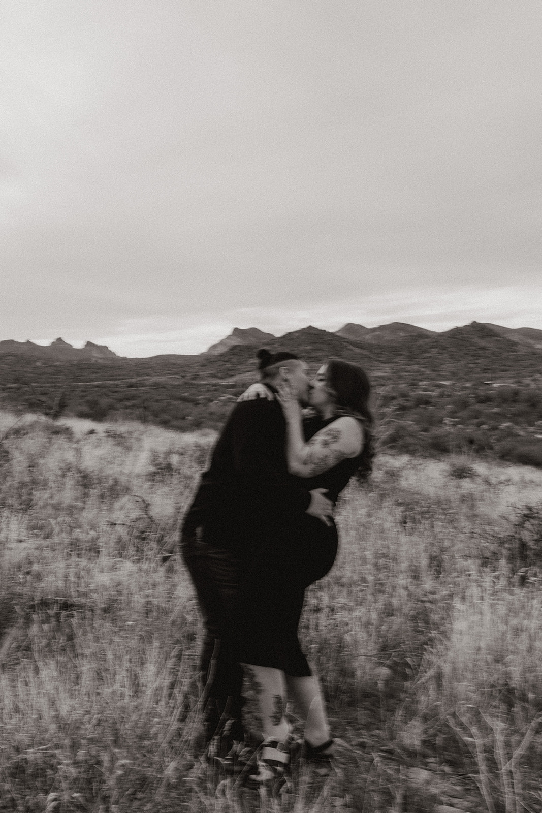 same sex couple pose together during their engagement photos at superstition mountain