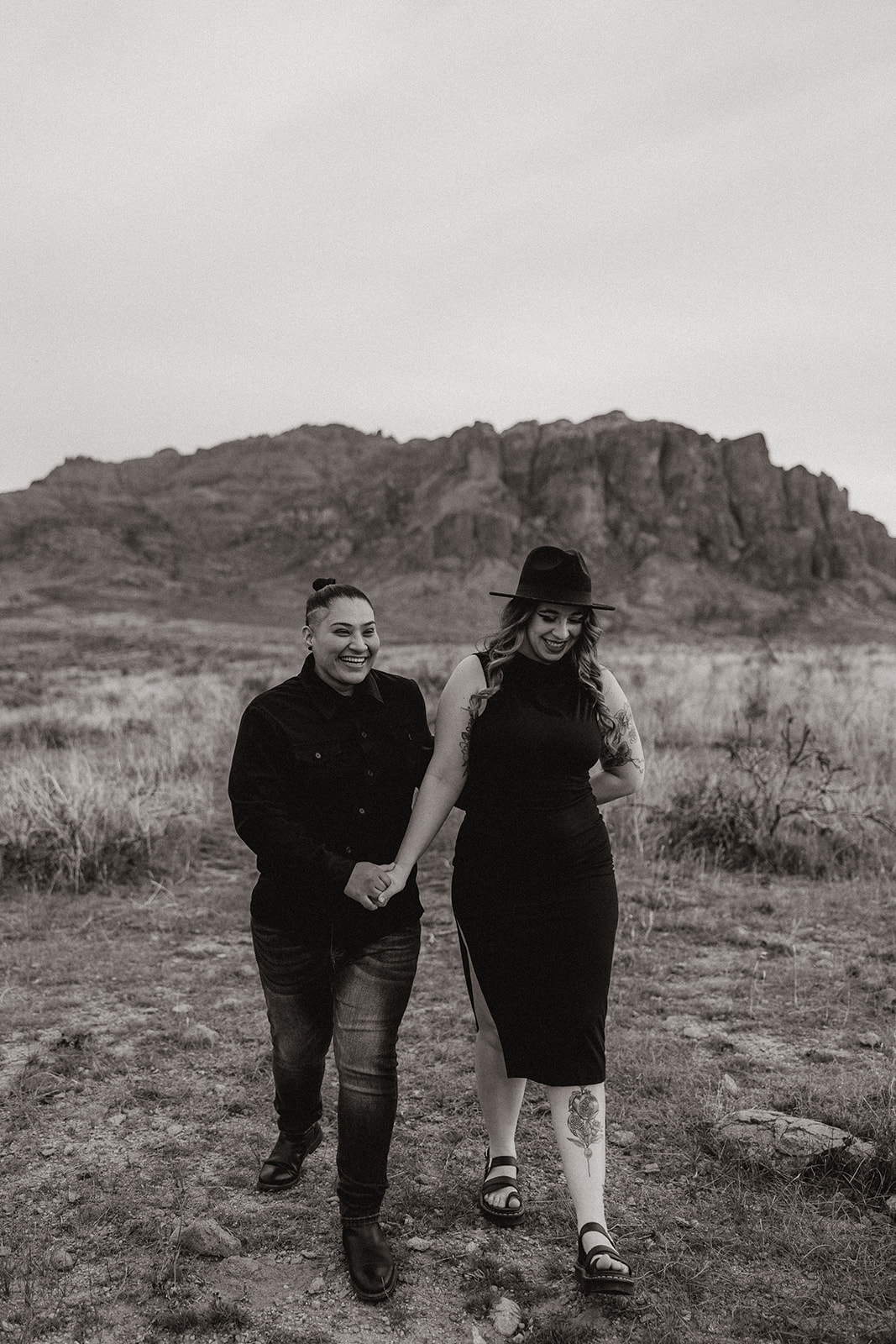 same sex couple pose together during their engagement photos at superstition mountain