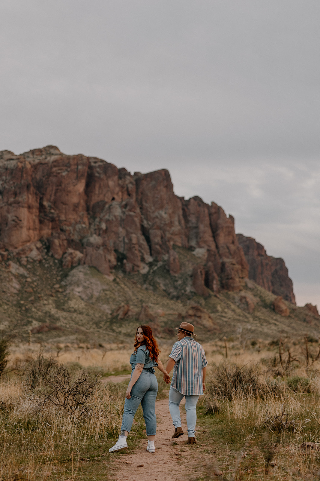 same sex couple pose together during their engagement photos at superstition mountain