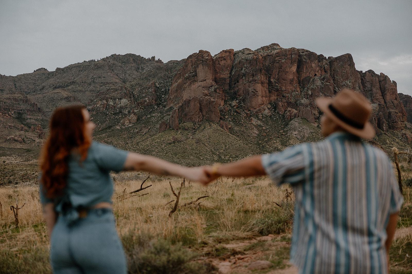 same sex couple pose together during their engagement photos at superstition mountain