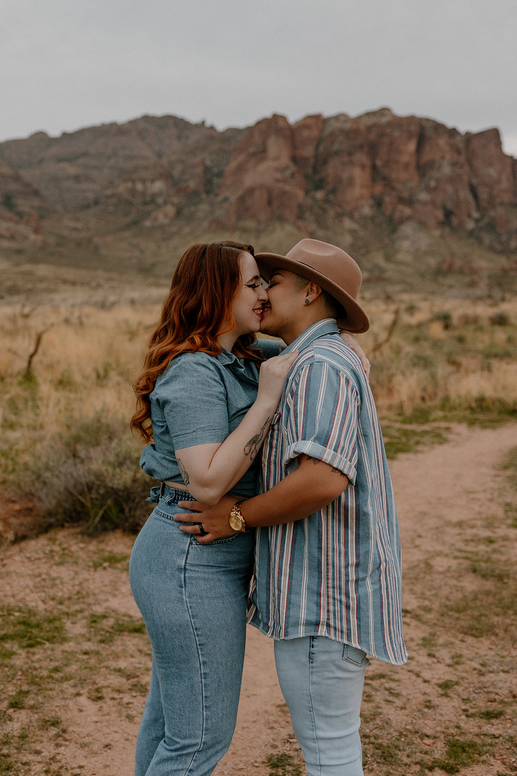 same sex couple pose together during their engagement photos at superstition mountain