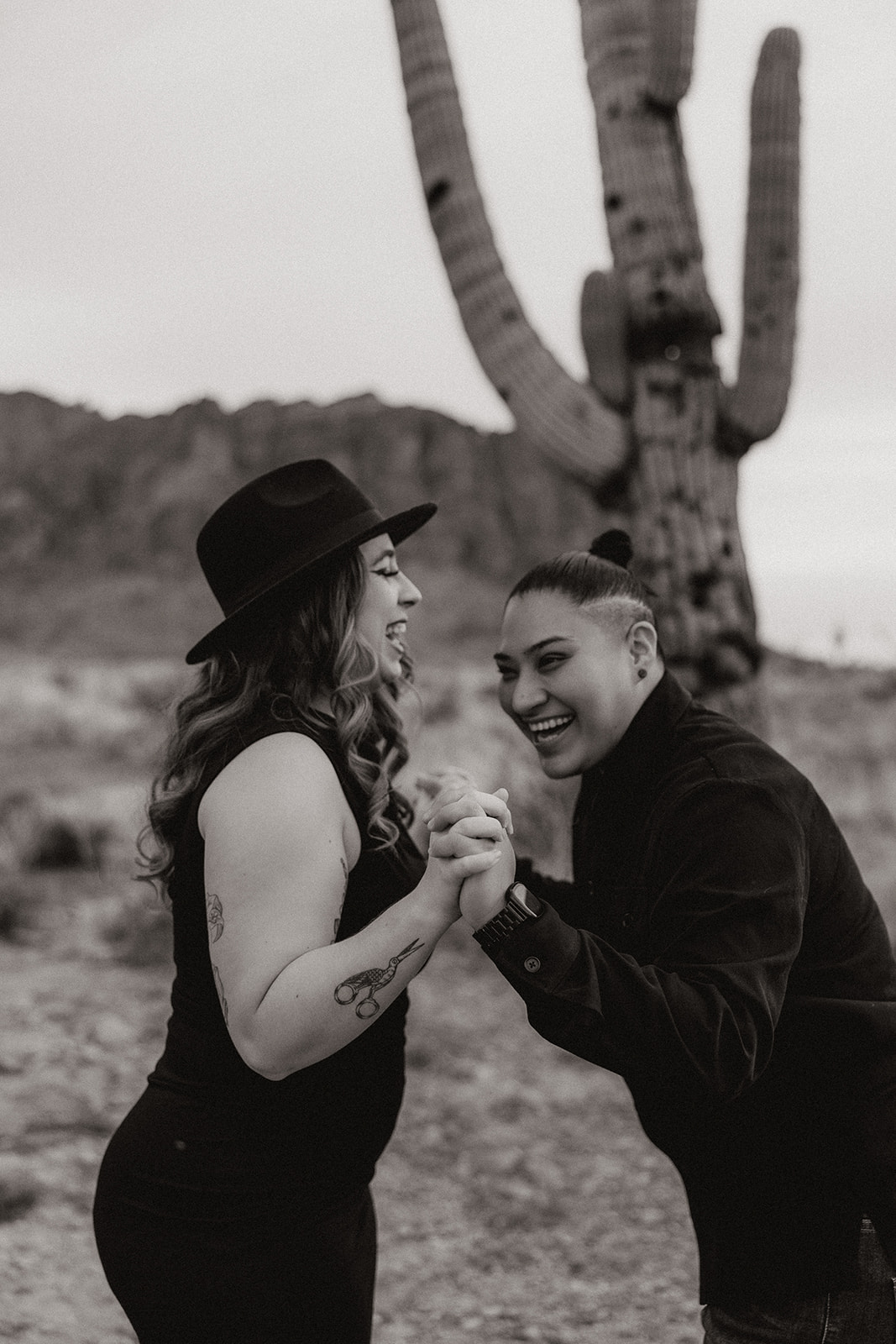 same sex couple pose together during their engagement photos at superstition mountain