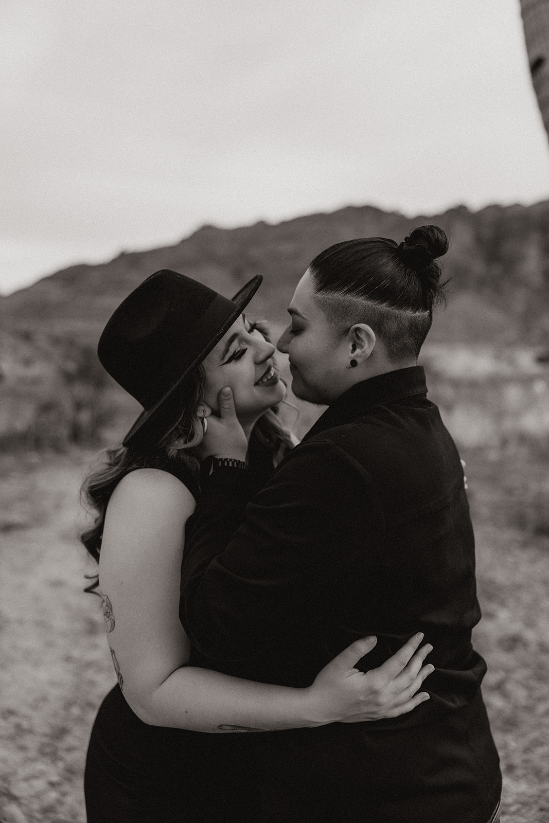 same sex couple pose together during their engagement photos at superstition mountain