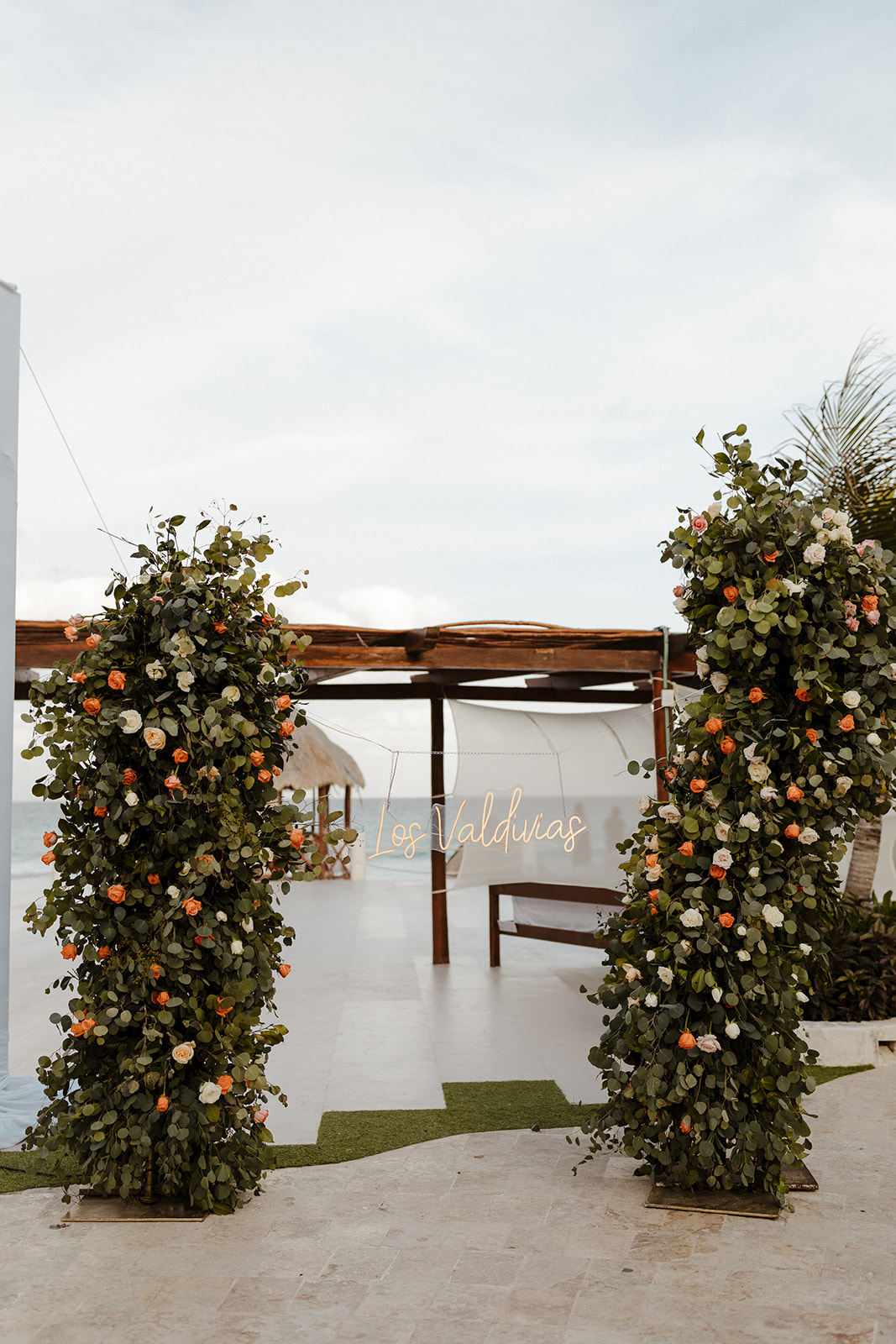 ceremony arch with pink, orange, and yellow florals