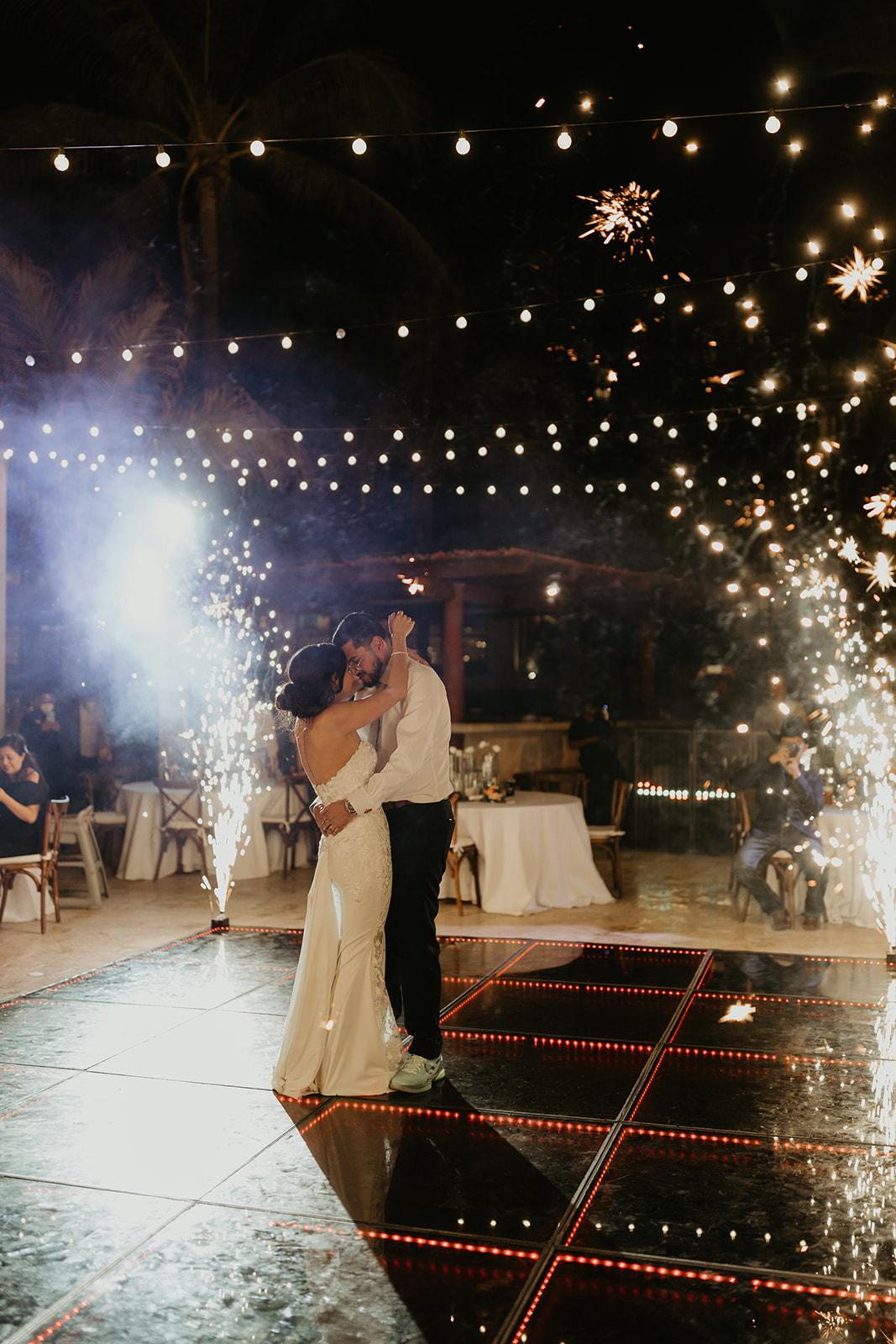 bride and groom share a dance during their destination wedding with sparklers