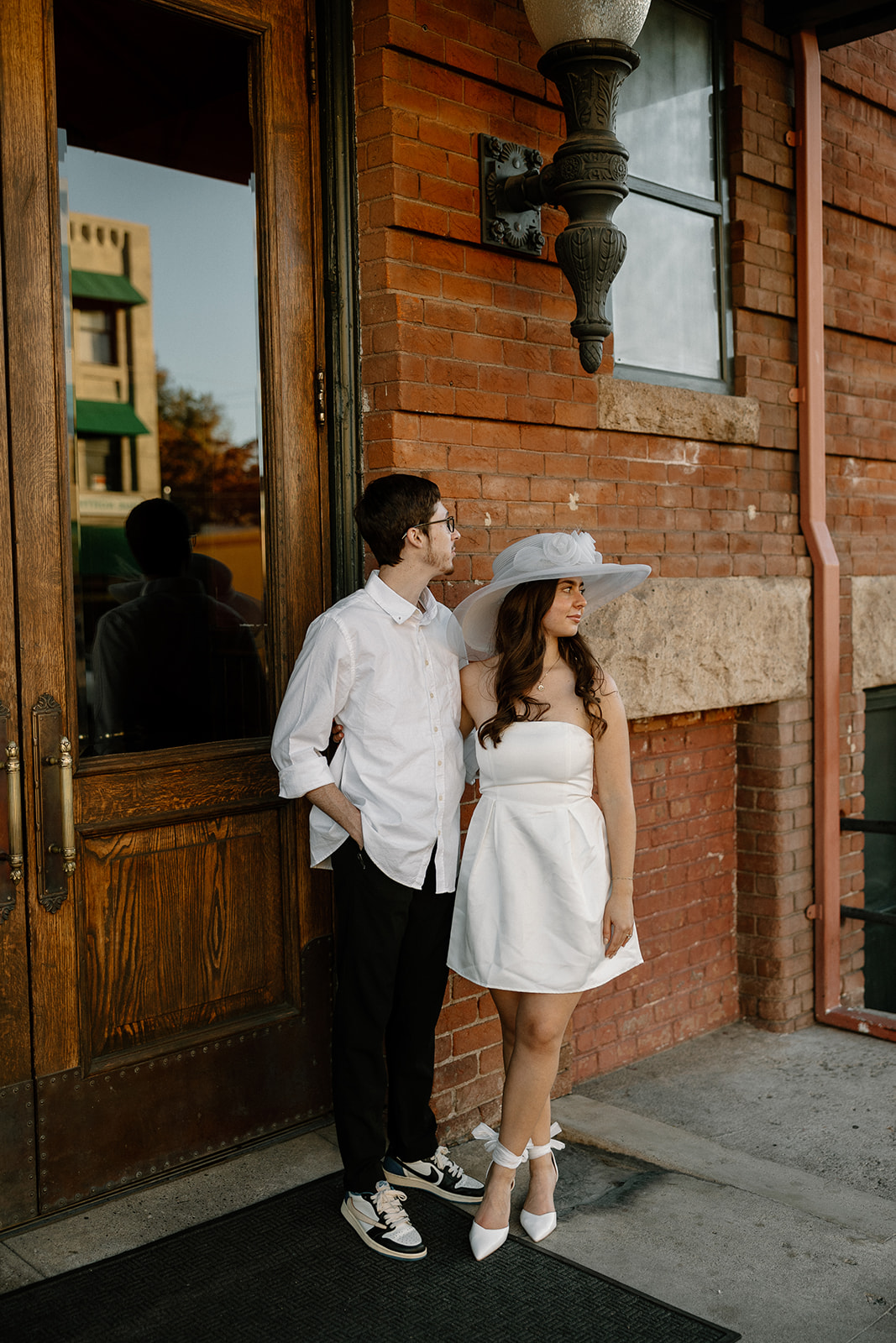 couple walking in downtown prescott during photoshoot in a white dress and white collard shirt