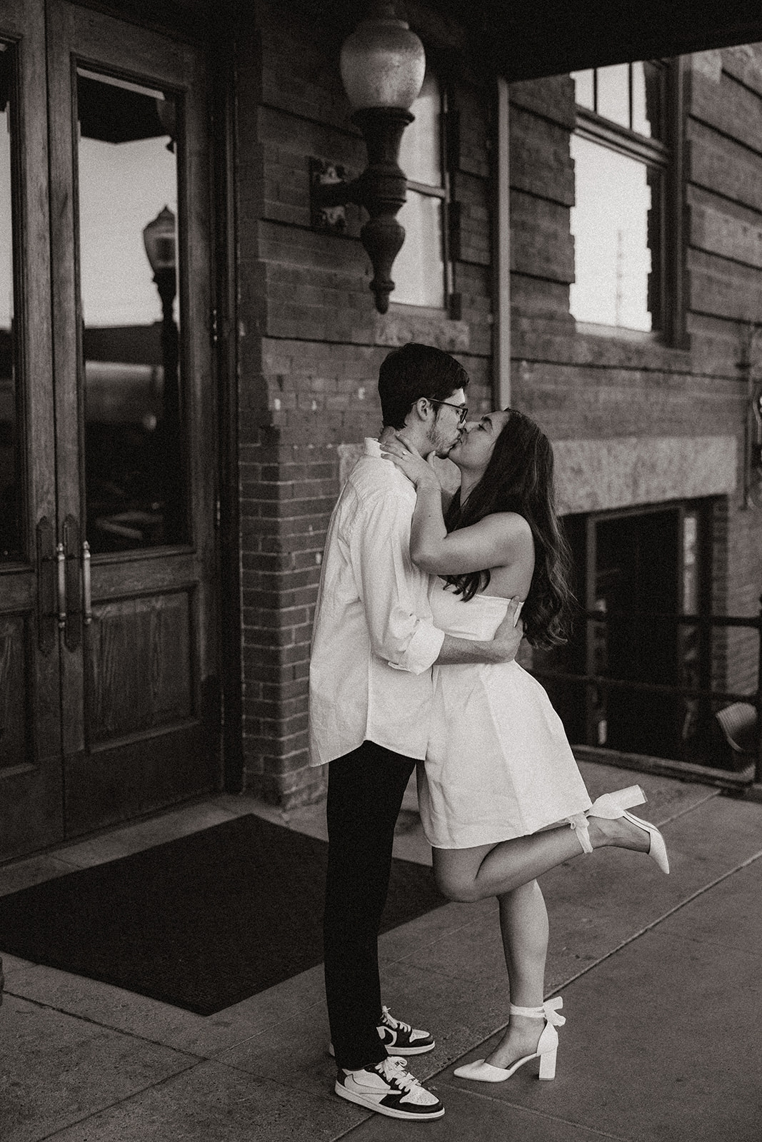 couple walking in downtown prescott during photoshoot in a white dress and white collard shirt