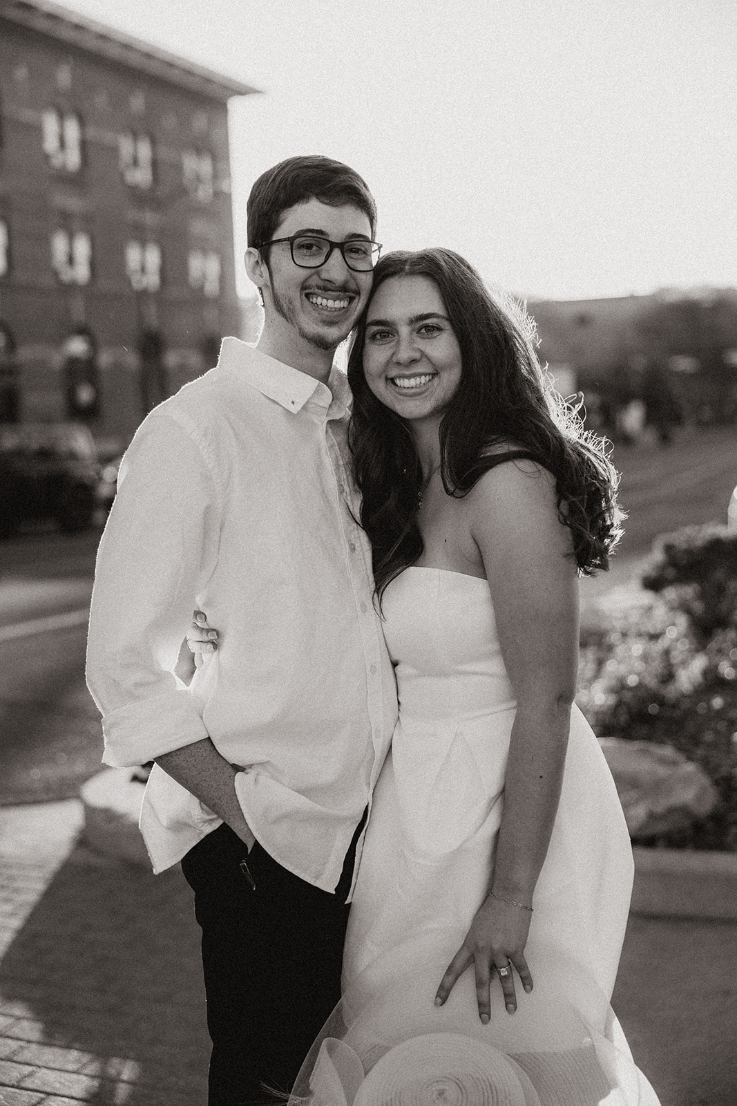 couple walking in downtown prescott during photoshoot in a white dress and white collard shirt