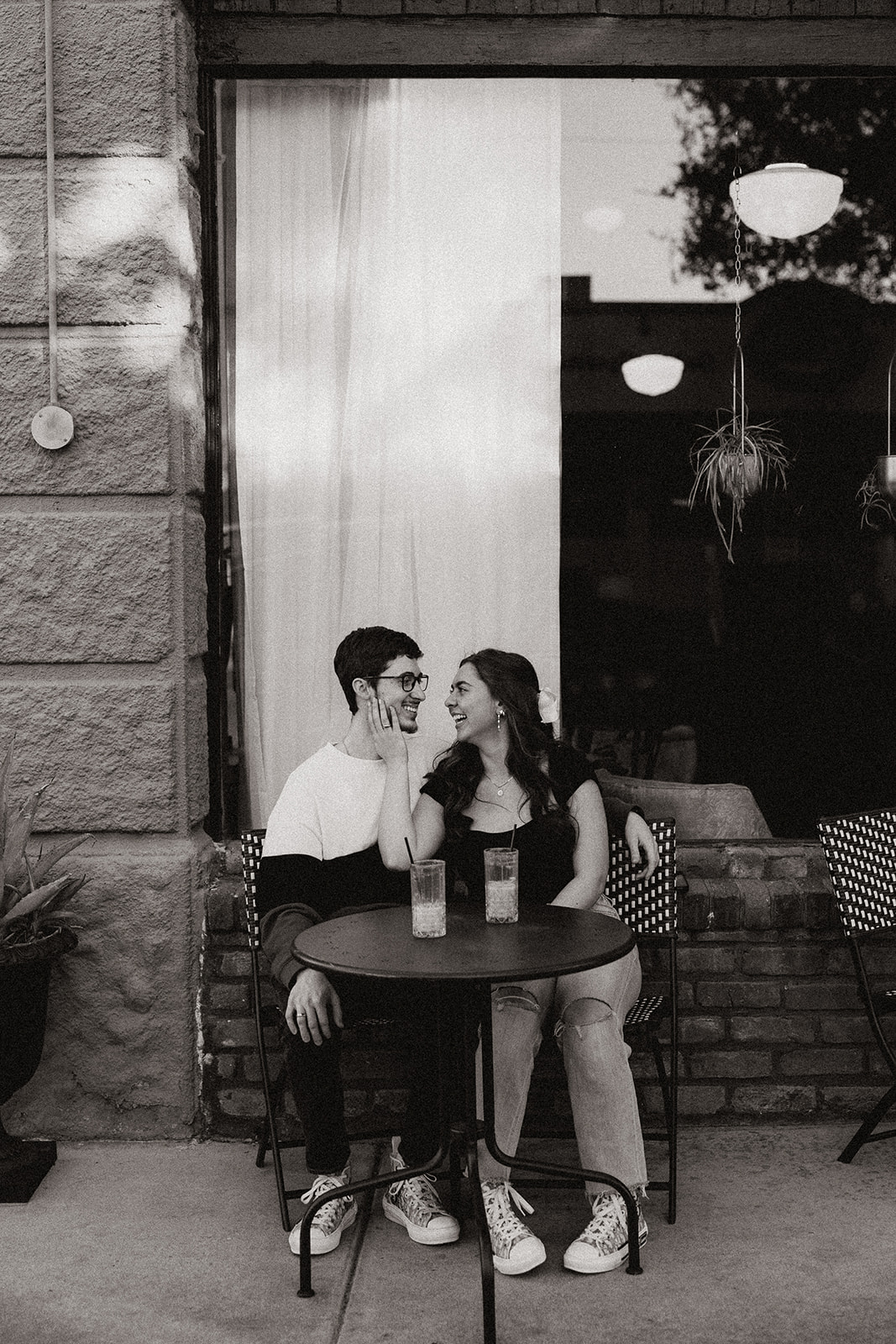 couple sips iced coffee outside of downtown prescott az on a black table and aztec bench