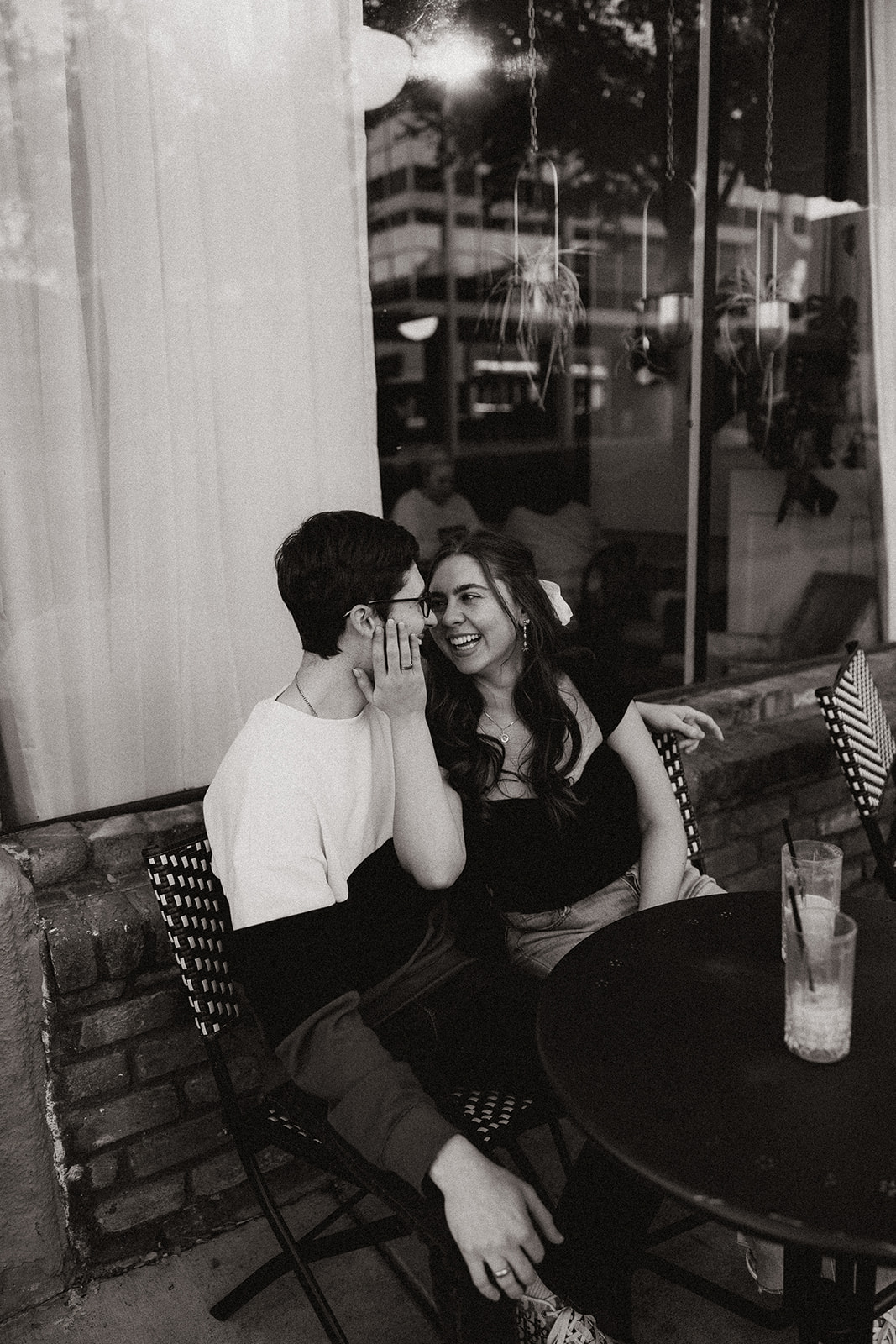 couple sips iced coffee outside of downtown prescott az on a black table and aztec bench