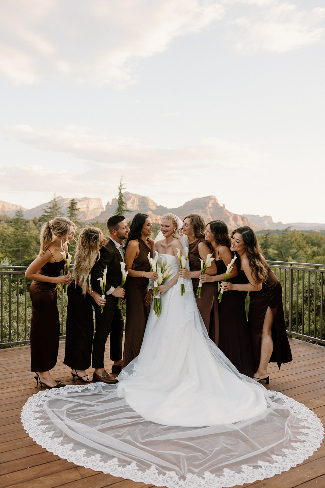 stunning bride poses with bridesmaids in all brown dresses