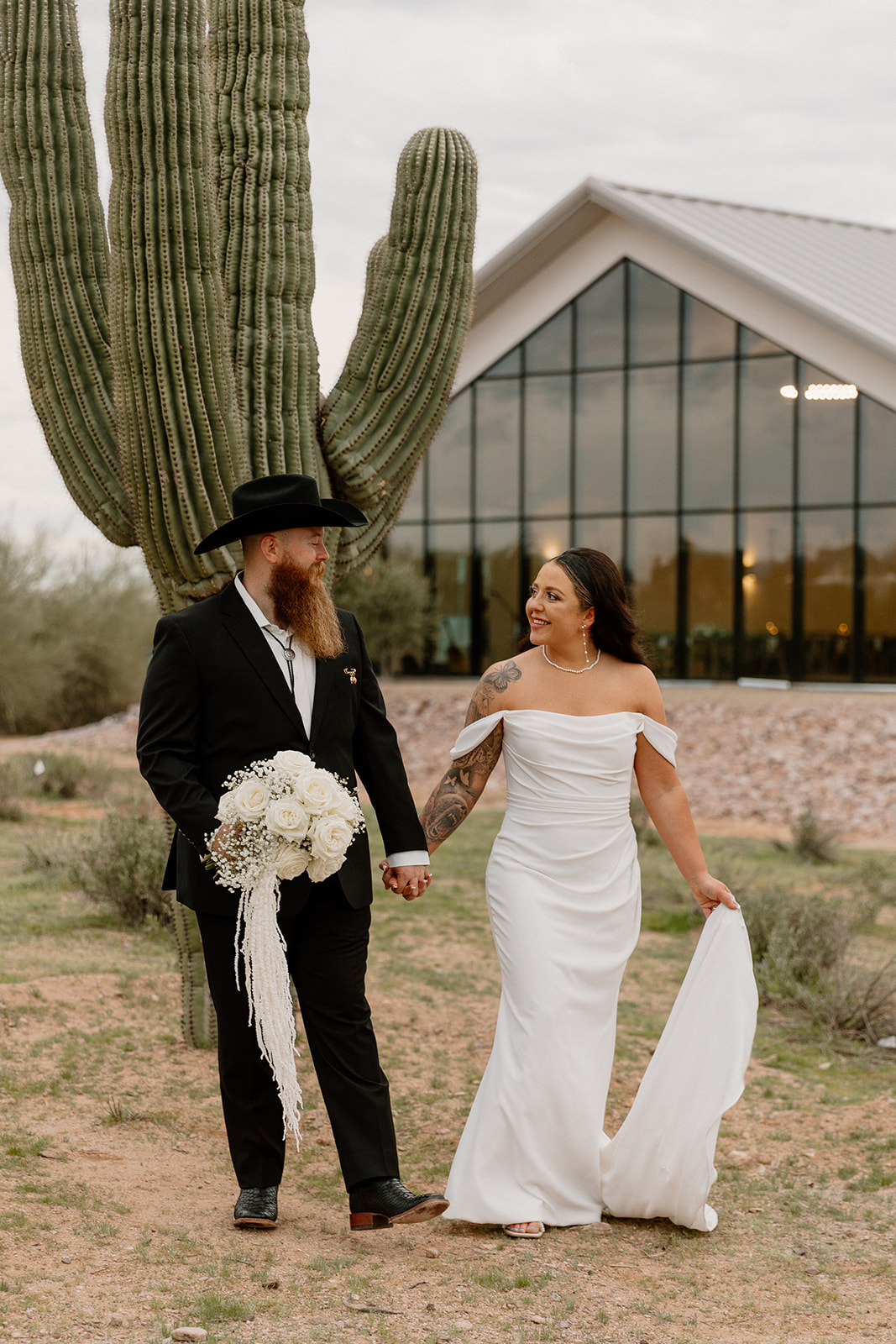 bride and groom pose together by a cactus